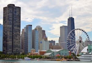 Chicago skyline featuring the iconic Ferris wheel on Navy Pier with skyscrapers like Hancock Tower.